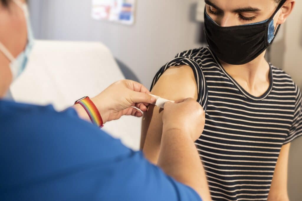 Coronaimpfung in der Apotheke: Mensch bekommt ein Pflaster auf den Oberarm